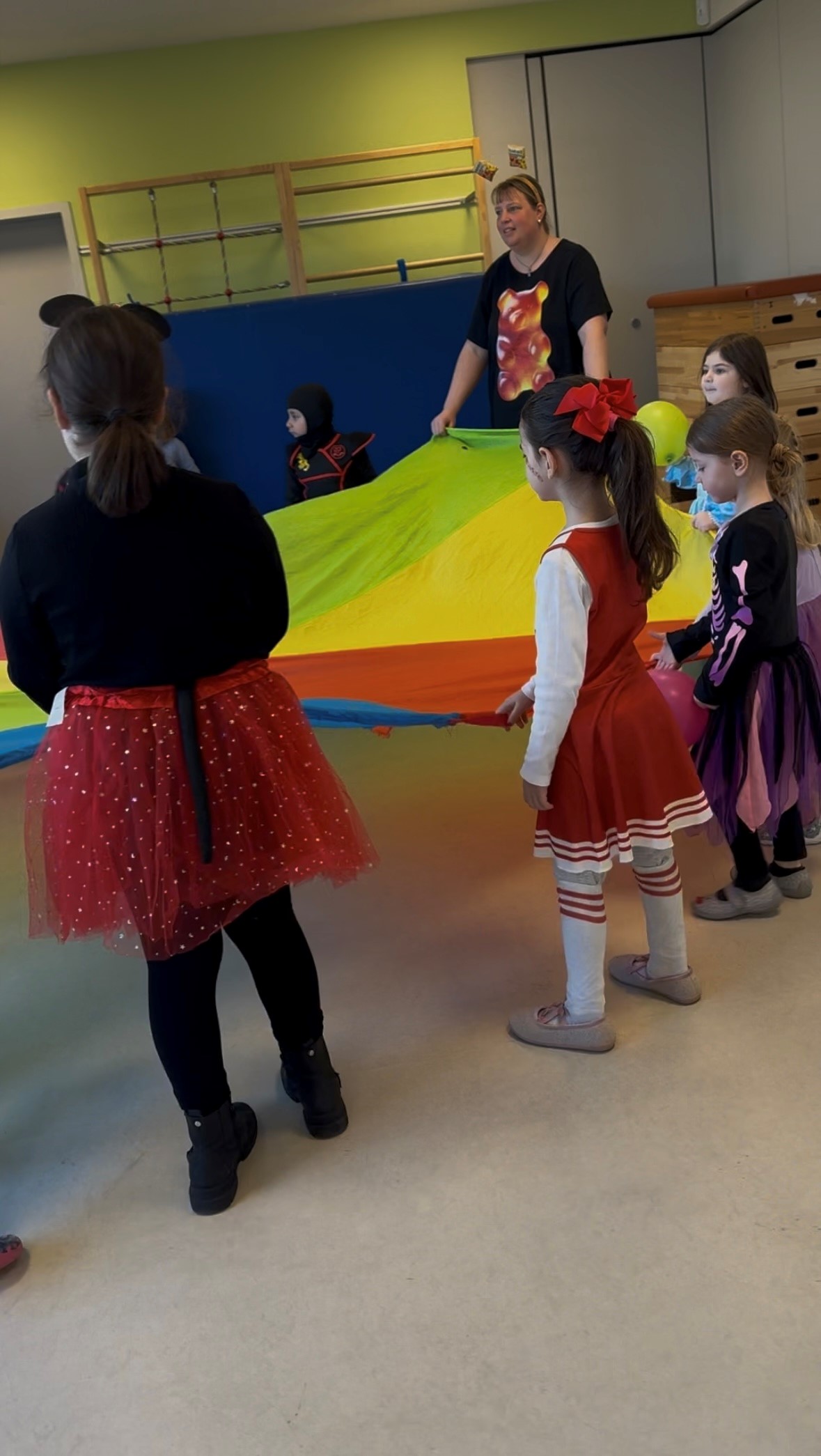 Kinder und Erzieher beim Spiel mit einem Schwungtuch