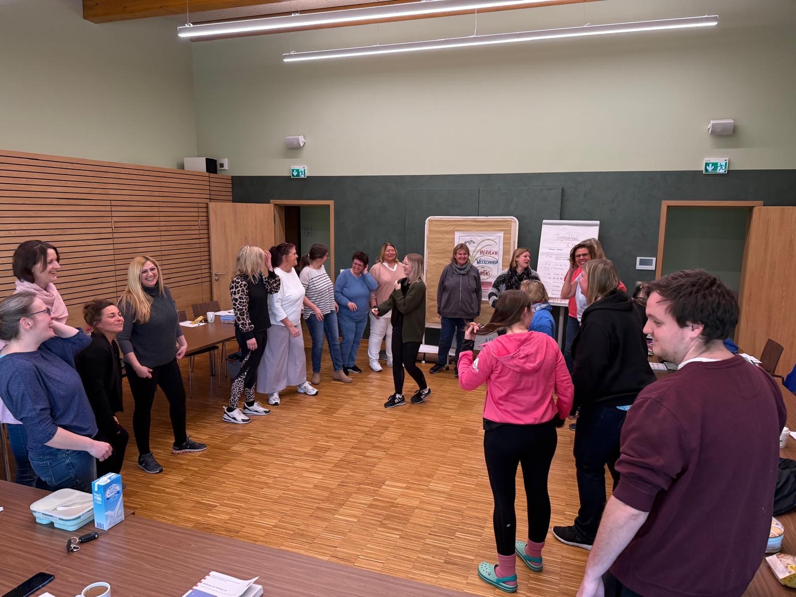 Fröhliche Stimmung bei den Erzieherinnen und Erzieher in einem Schulungsraum