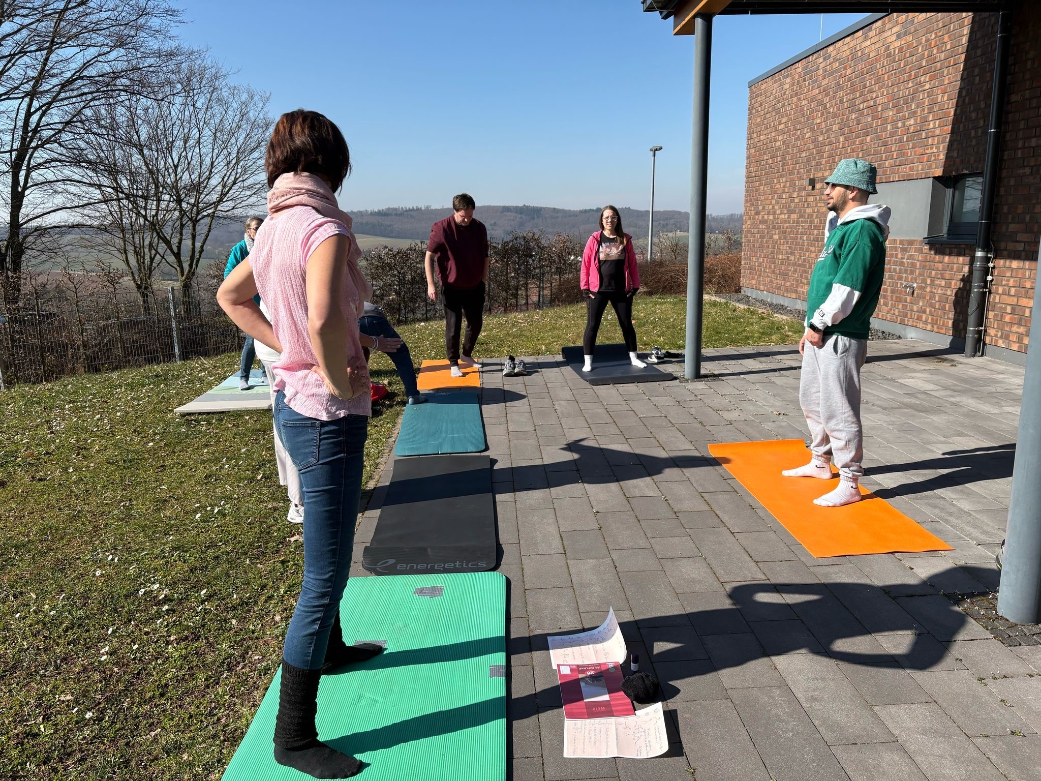 Erzieherinnen und Erzieher bei einer Yoga -Pause draußen