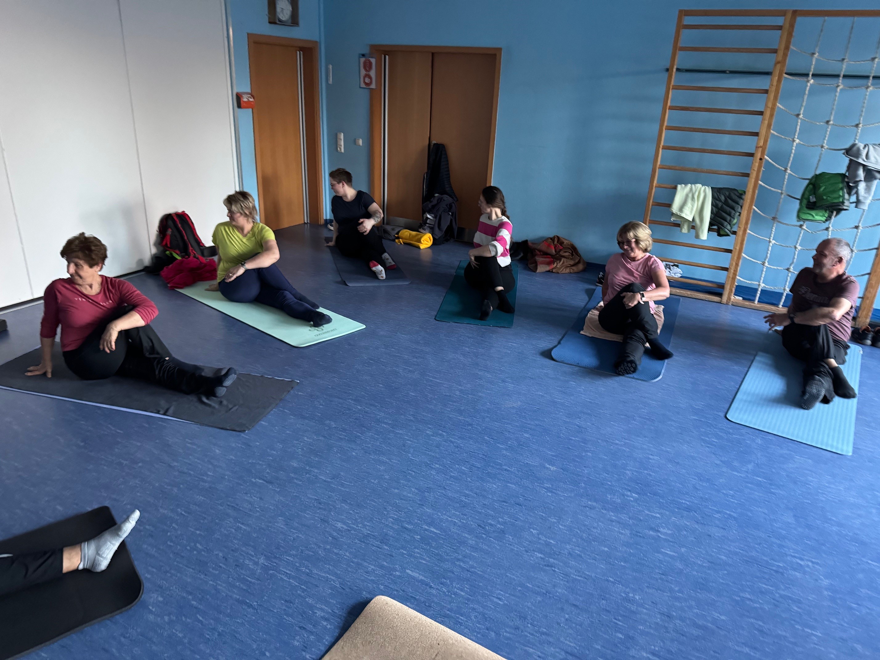 Menschen beim Turnen auf Yogamatten