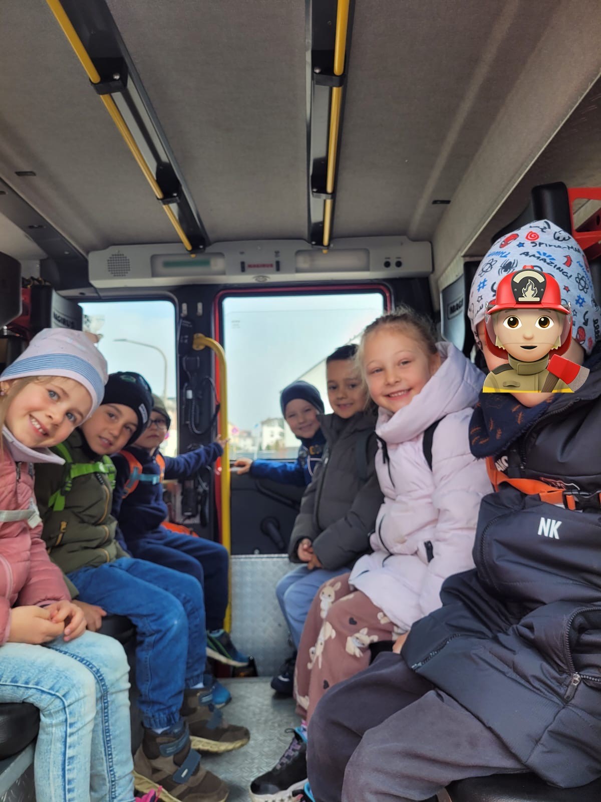 Kindergartenkinder sitzen im Feuerwehrauto