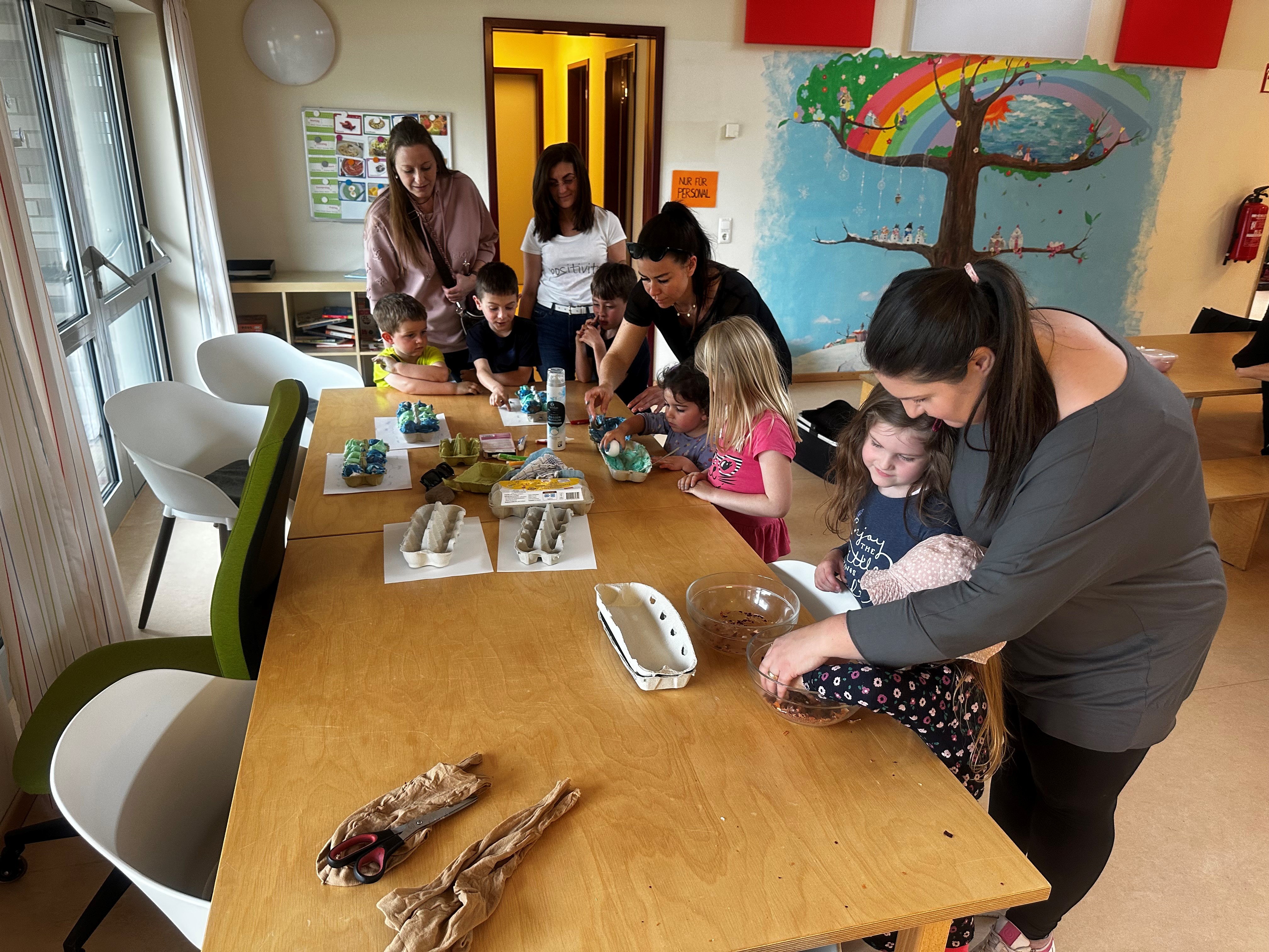 Eltern und Kinder beim Ostereierfärben