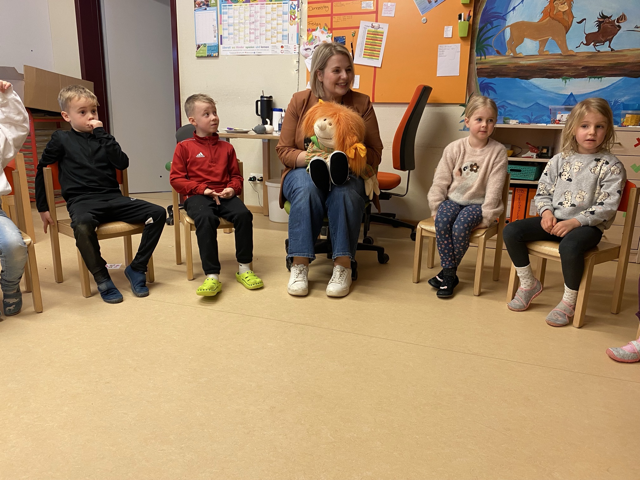 Patenzahnärztin mit Handpuppe und Kinder im Stuhlkreis