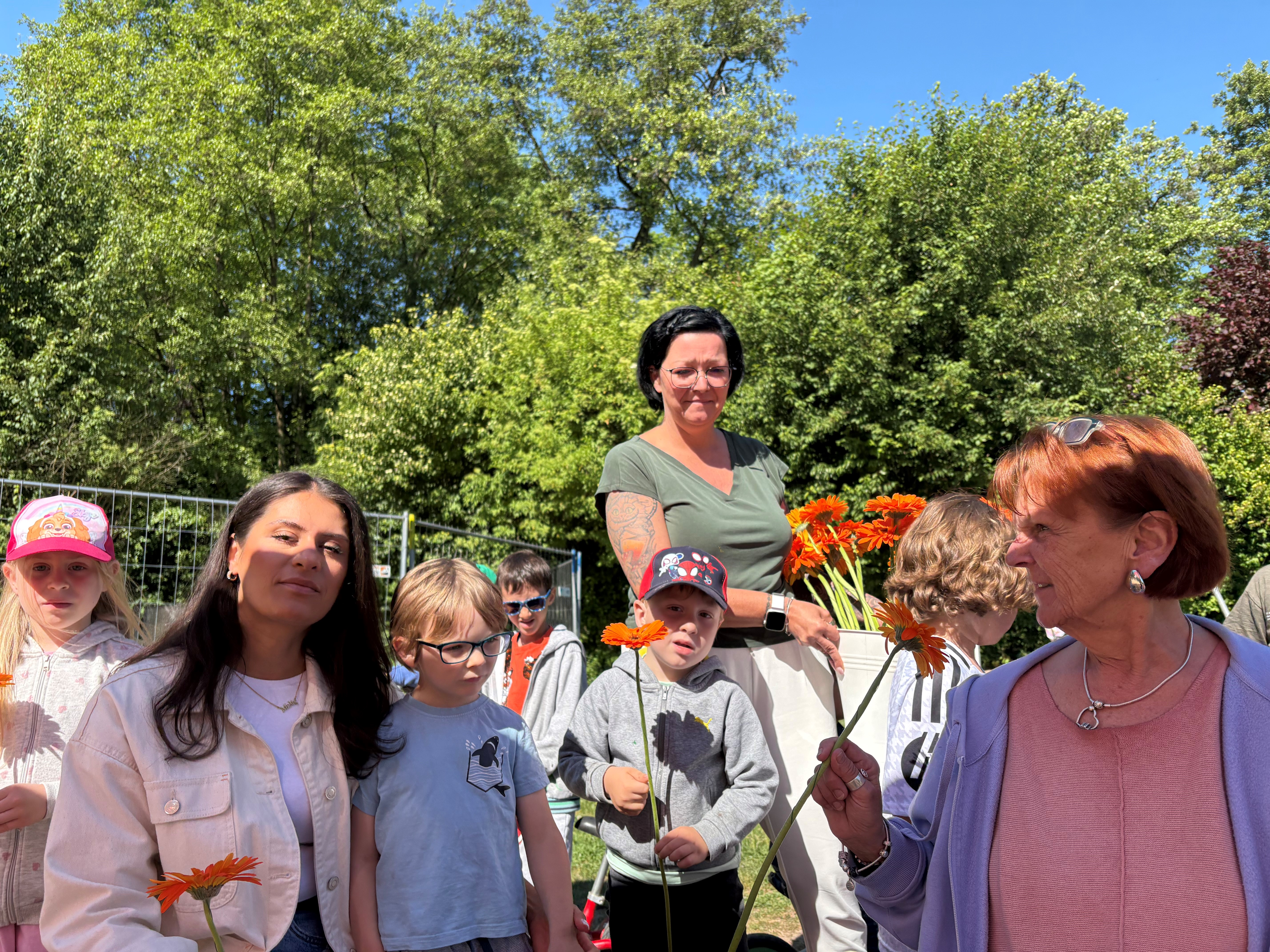 Kinder überreichen eine Blume an einen Erzieherin
