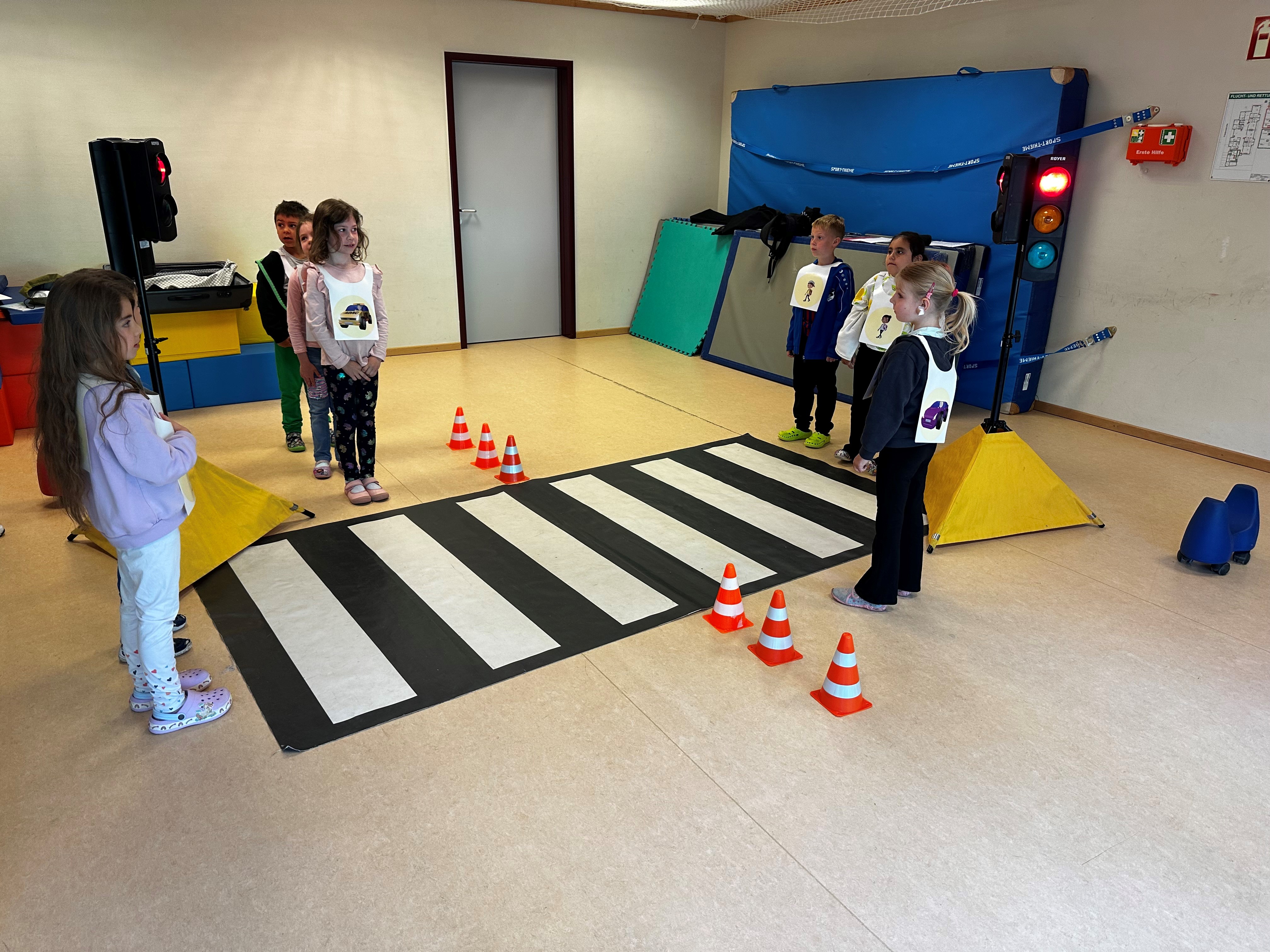 Kinder spielen Straßenverkehr mit Modell-Ampel und -Zebrastreifen