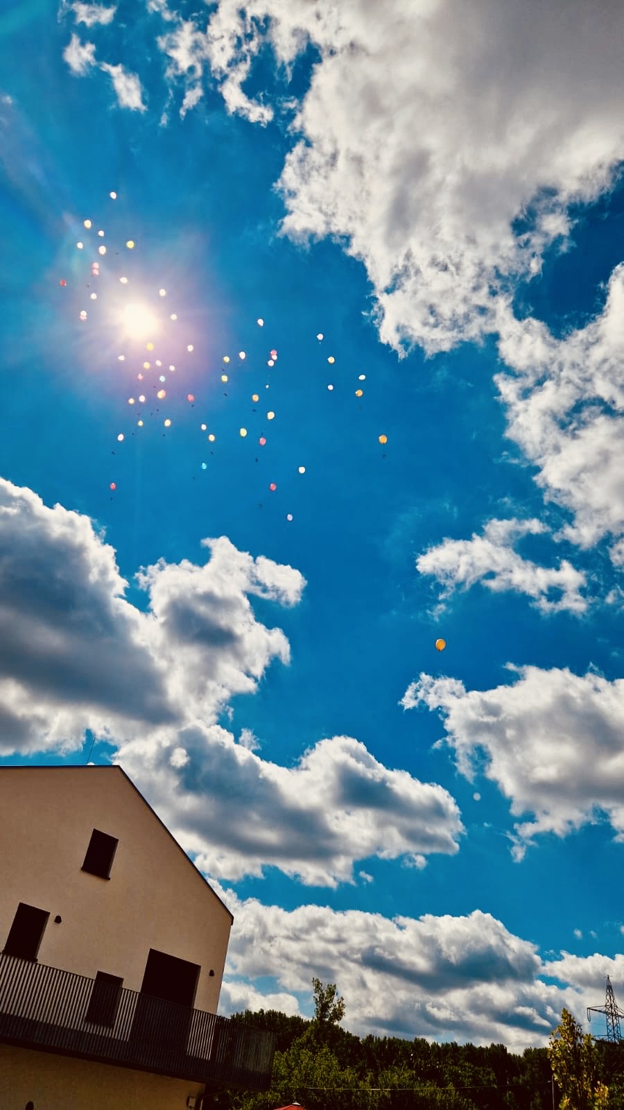 Blauer Himmel mit davonfliegenden Luftballons