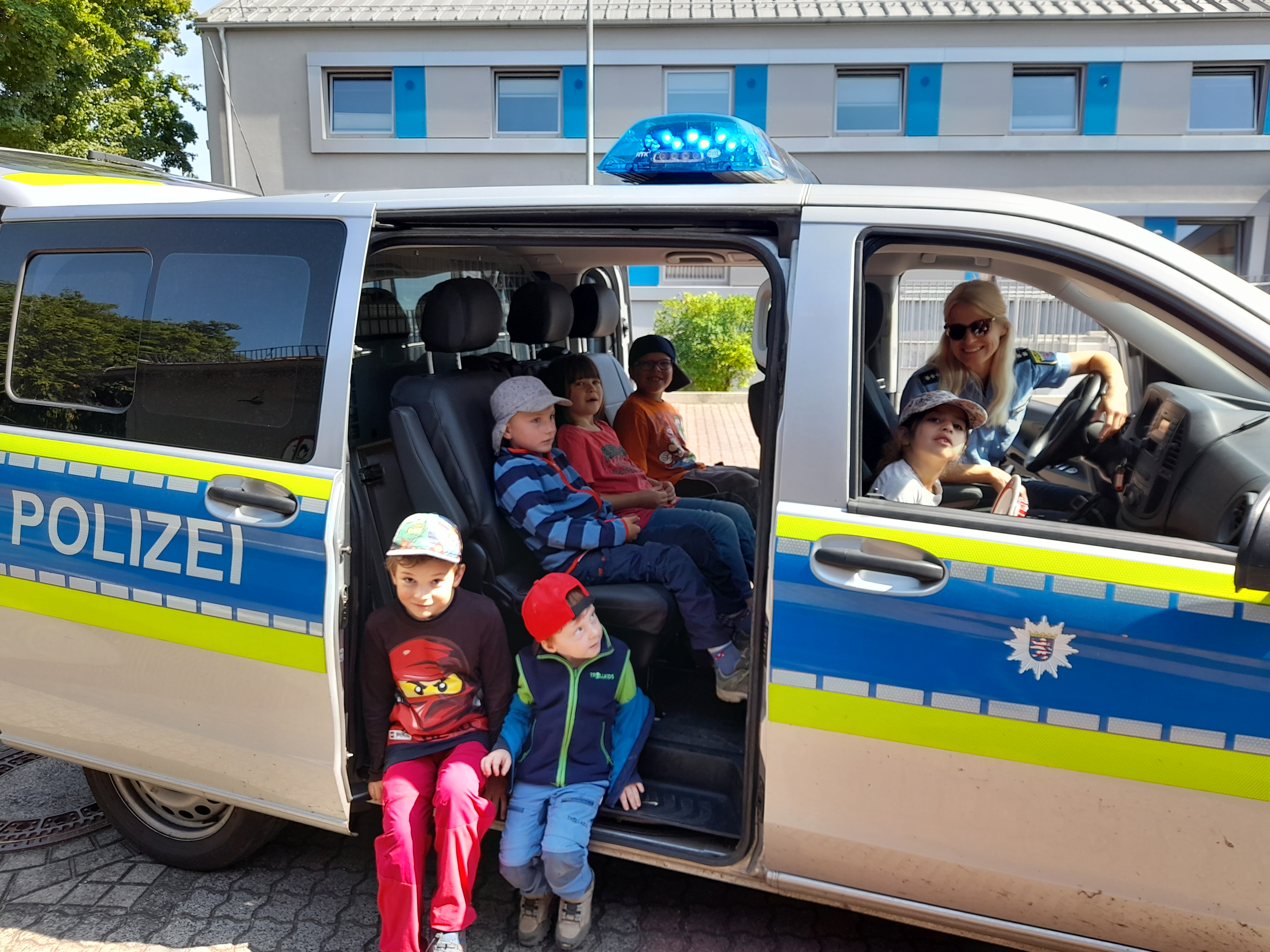 KiTa-Kinder dürfen in einem Polizeiauto sitzen