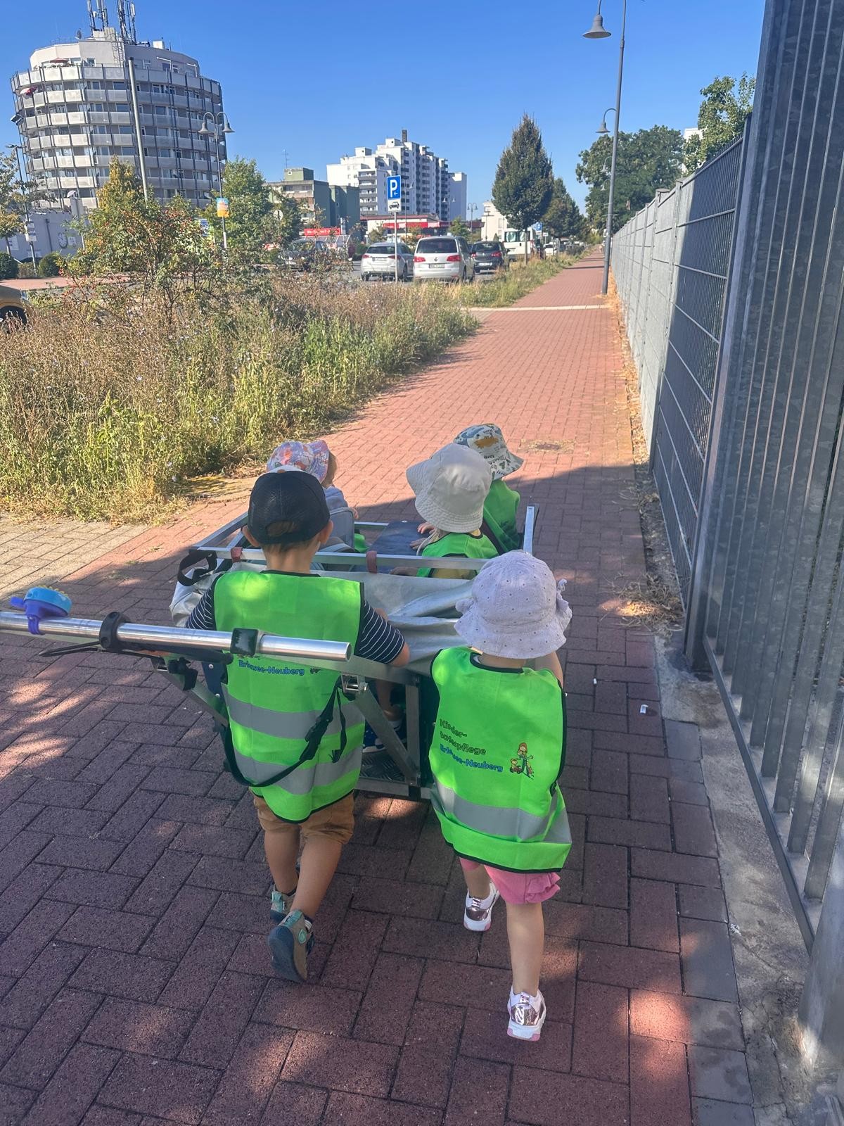 Krippenwagen mit Kindern wird von Kinder geschoben