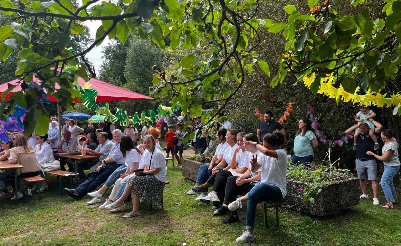 Blick in den bunt dekorierten Garten mit vielen Besucherinnen und Besuchern