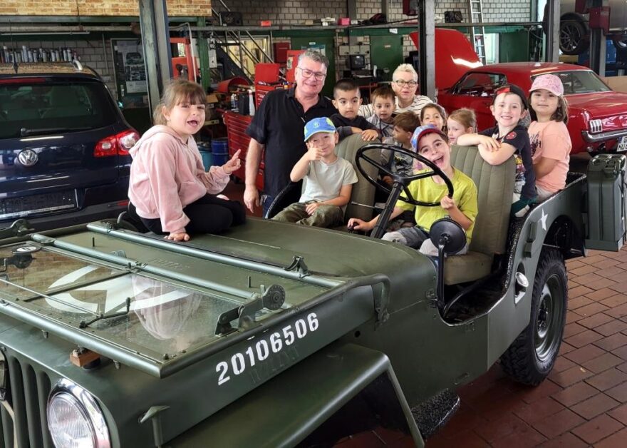 Kinder zusammen mit Fred Hestermann in einem Jeep
