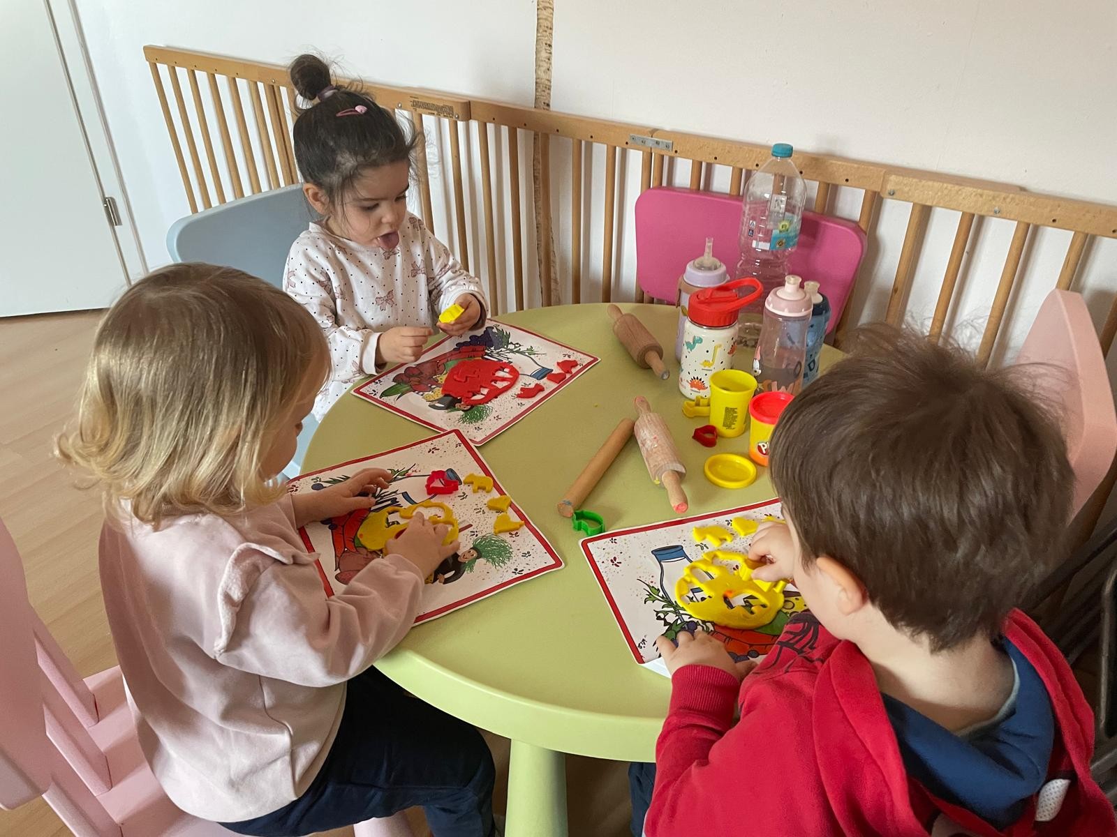 Kinder beim Kneten am Tisch sitzend