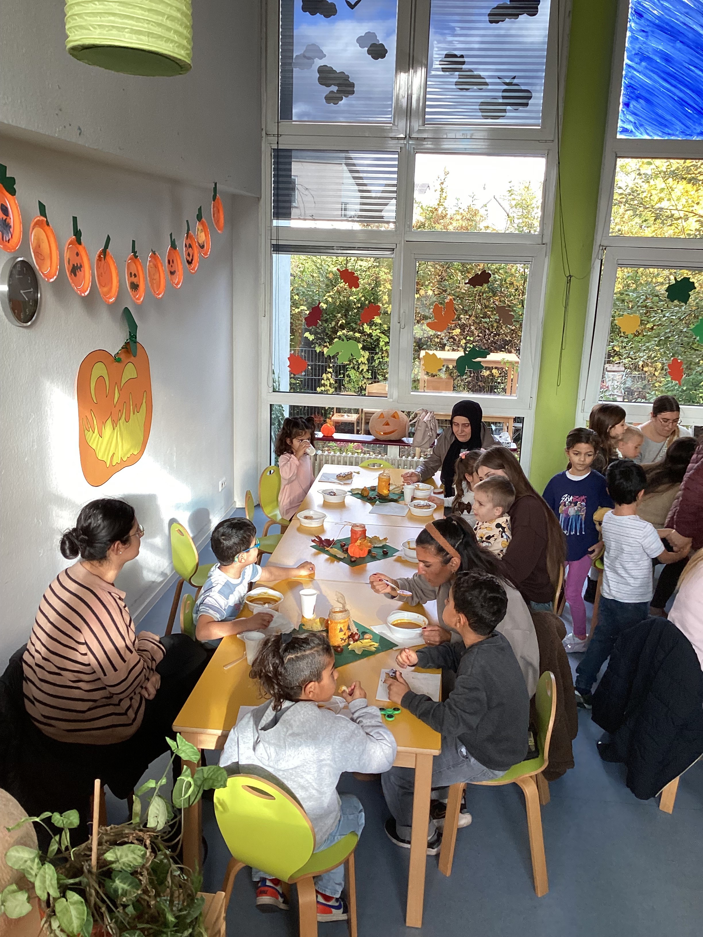 Kinder und Eltern beim Suppe-Essen im herbstlich geschmückten Gruppenraum