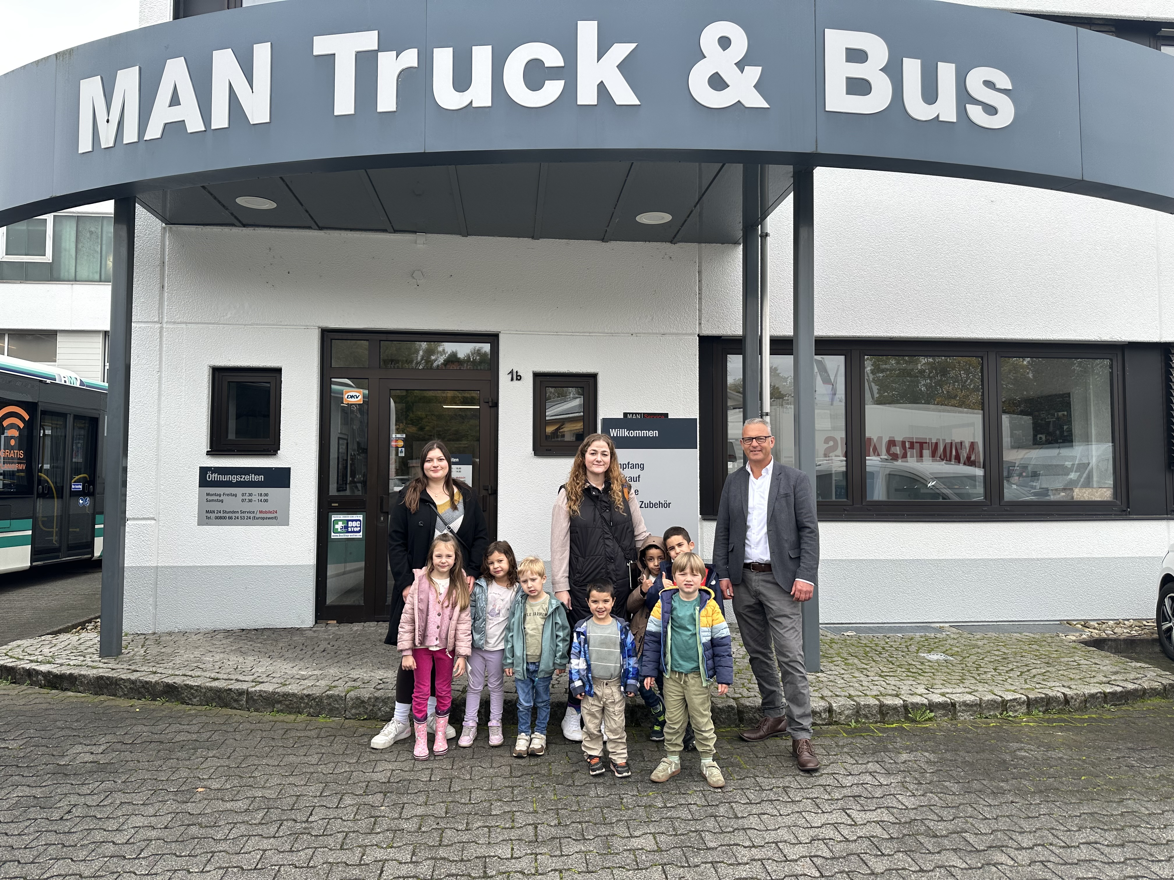 Kinder, Erzieherinnen und Oliver Hirt vor dem MAN-Gebäude