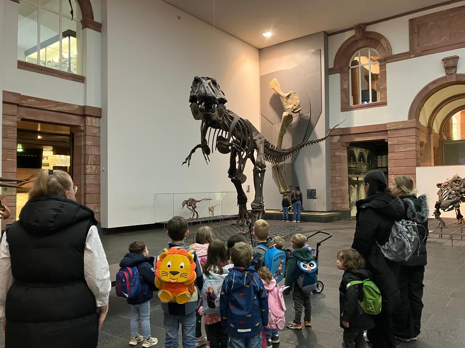 Kinder im Senckenbergmuseum vor einem riesigen Dinosaurier-Skelett