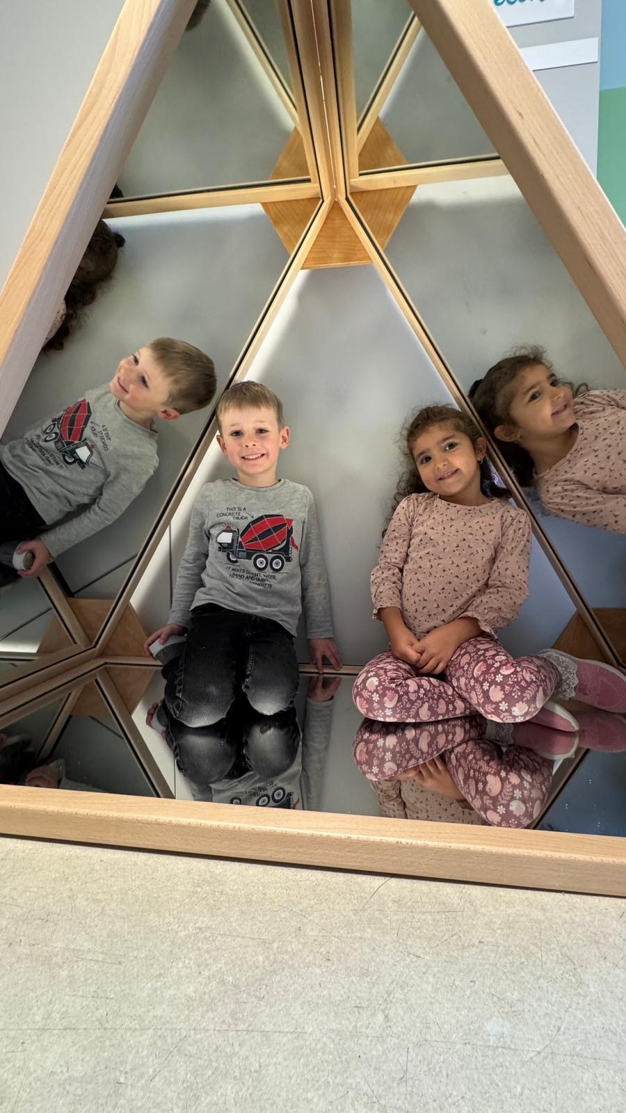 Kinder spiegeln sich in der Spiegelpyramide