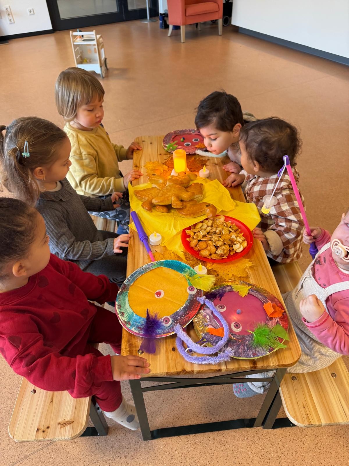 Kinder am Tisch mit Laternen und Weckmännern