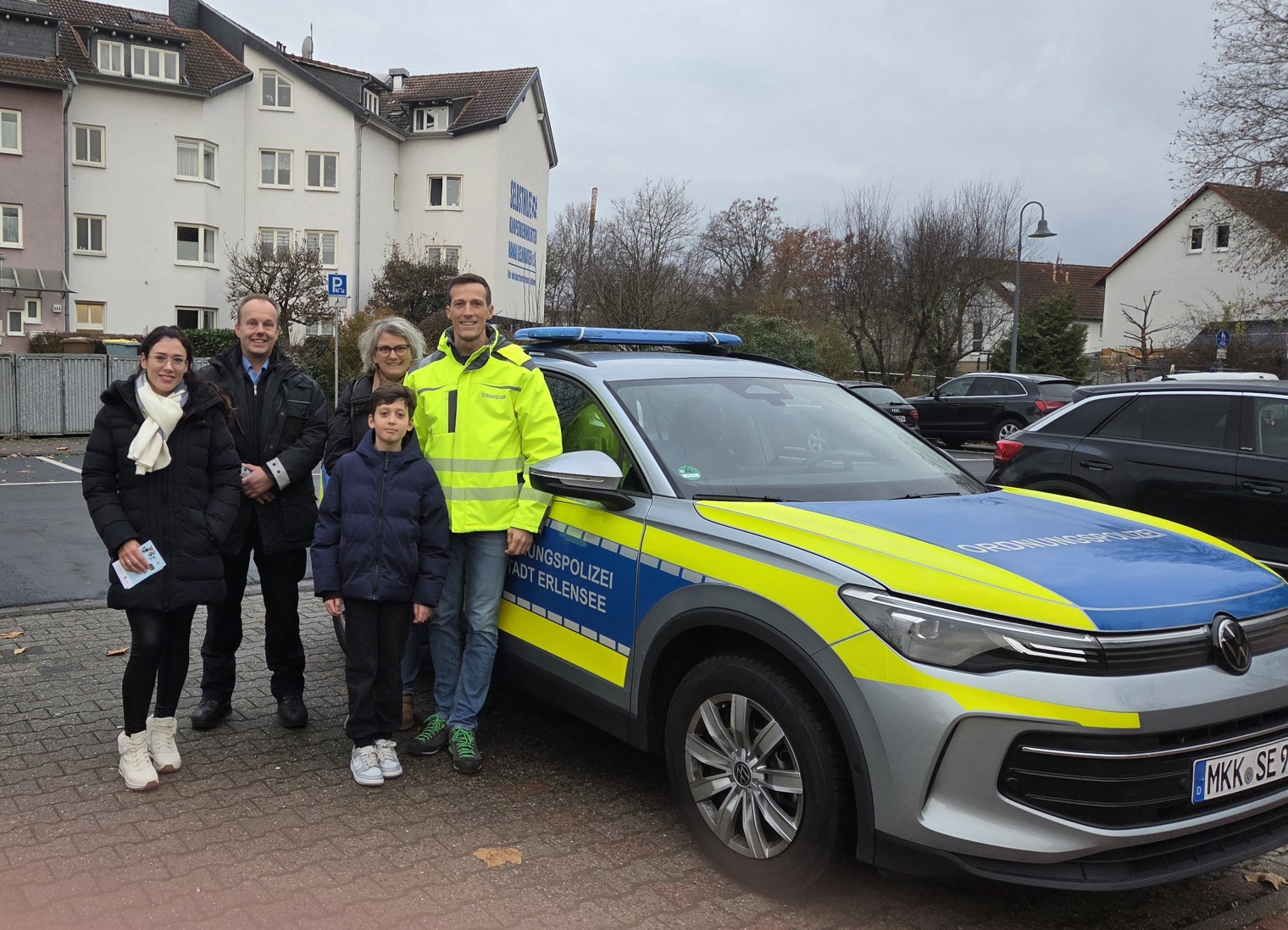 Mutter Elvira Renkel, der Ortspolizist Christoph Hixt, die Fachdienstleitung für Kinderbetreuung und Jugendliche Sandra Wunder, Leonard Renkel und der Leiter des Ordnungsamtes Marc Schilling vor dem Polizeiauto