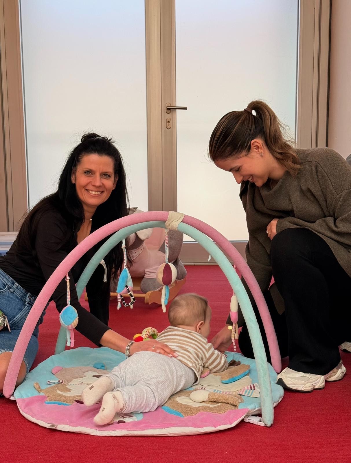 Zwei pädagogische Fachkräfte mit einem Baby