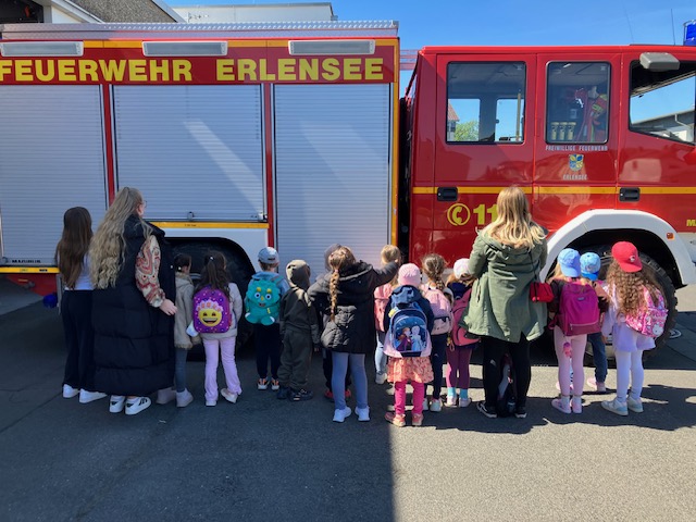Die Kinder bestaunen eines der riesiger Feuerwehrautos
