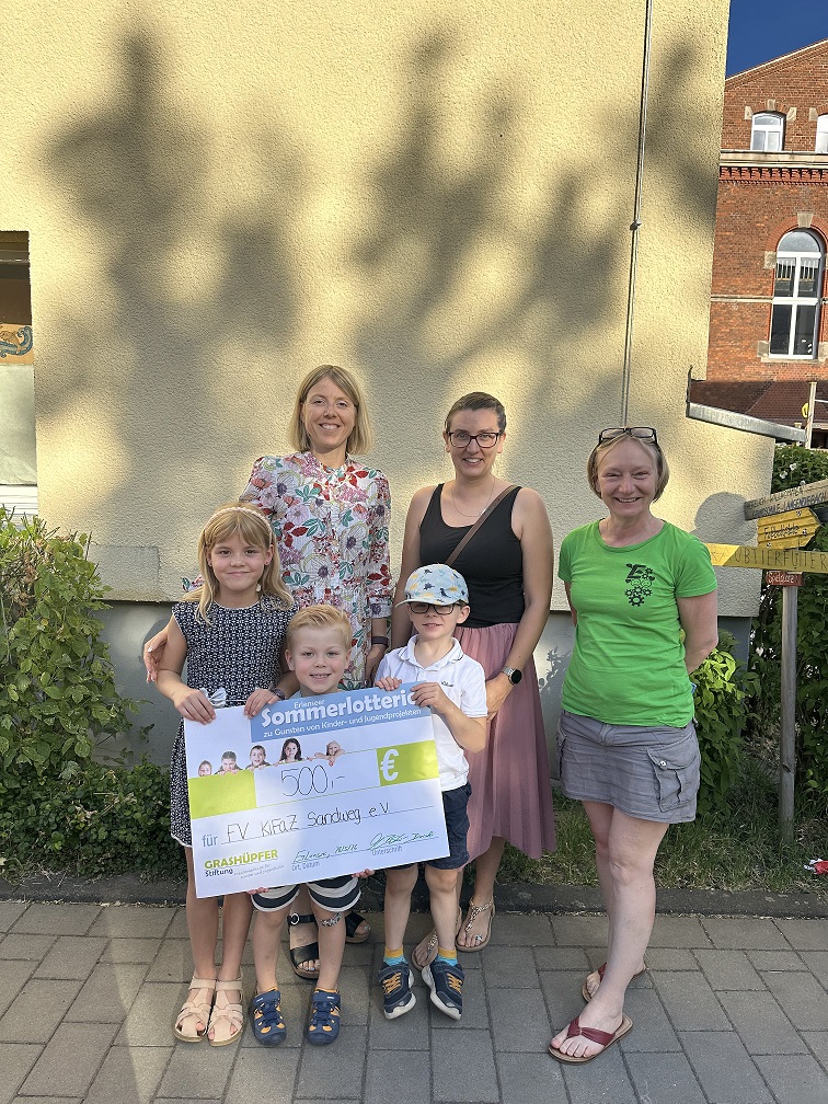 Vorstandsmitglieder Förderverein KiFaZ Sandweg und Kinder mit dem Spendenscheck