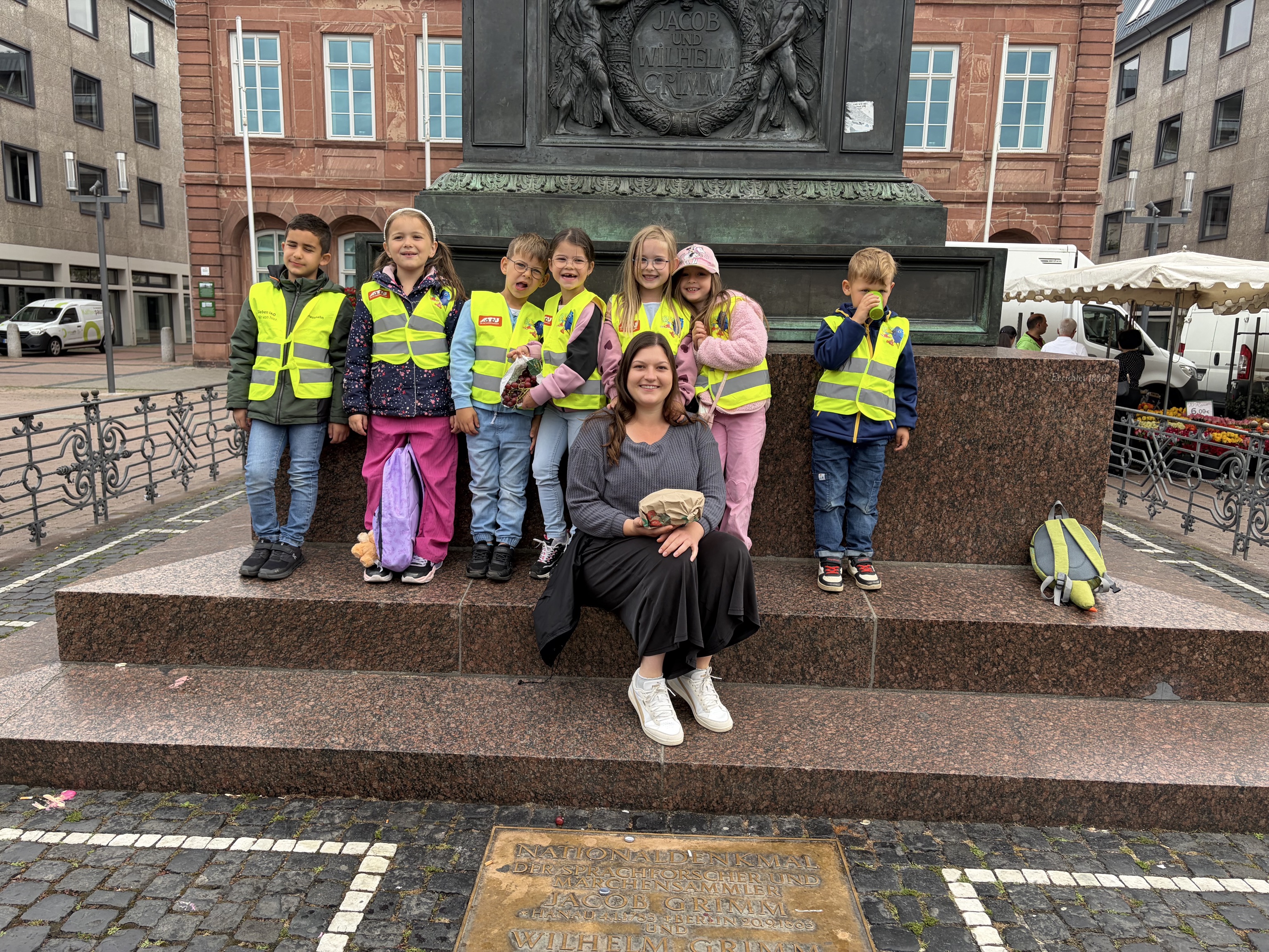 Die Kinder mit Erzieherin vor dem  Brüder-Grimm-Denkmal in Hanau