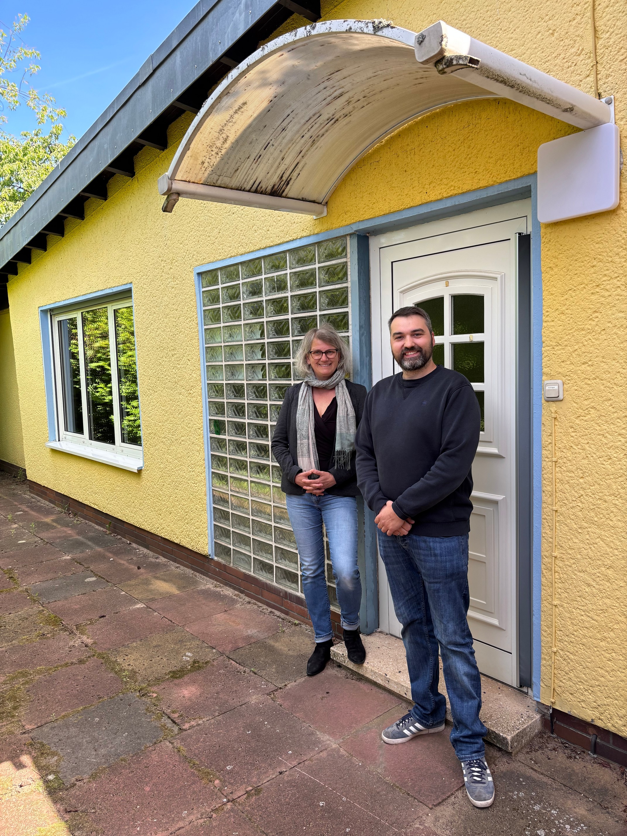 Fachdienstleitung Sandra Wunder zusammen mit KiTa-Leitung Florian Gardlowski vor der kleinen Villa